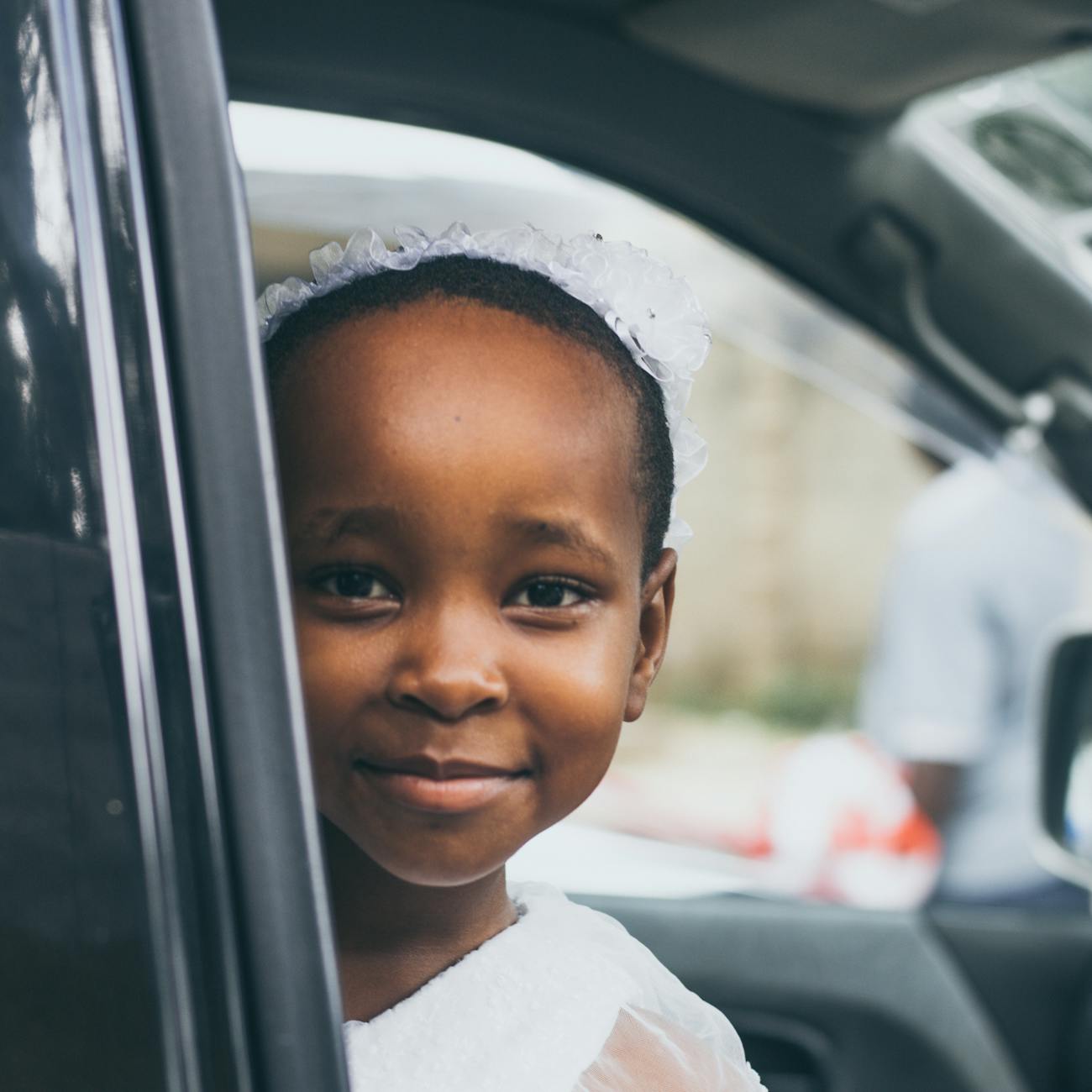 smiling girl wearing white top inside car