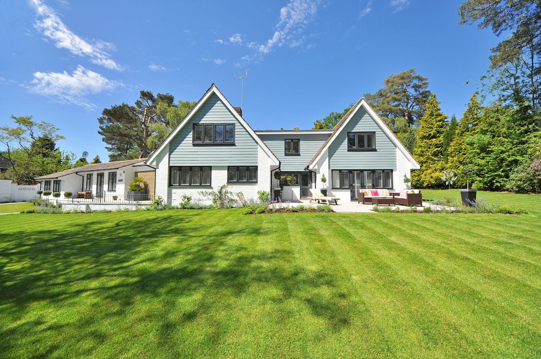 white and gray wooden house near grass field and trees