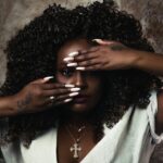 woman in white shirt covering her face with her hand