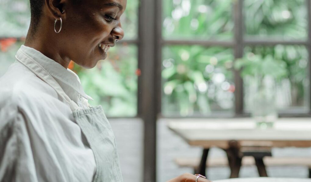 cheerful black woman sitting at table in restaurant