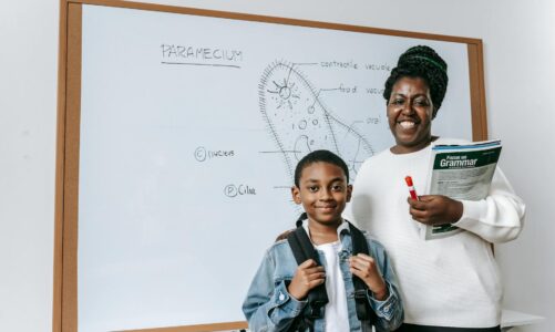 cheerful black woman with student against whiteboard