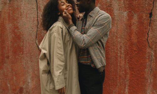 happy couple standing near a red wall