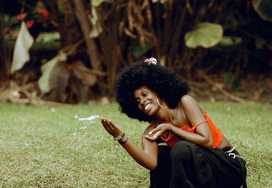 joyful woman by stream in lush greenery