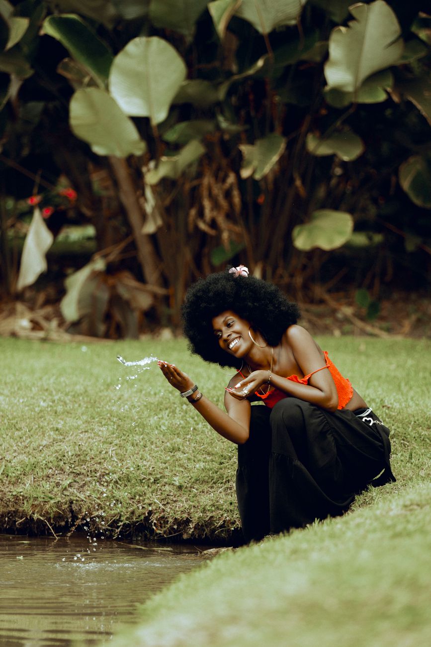 joyful woman by stream in lush greenery